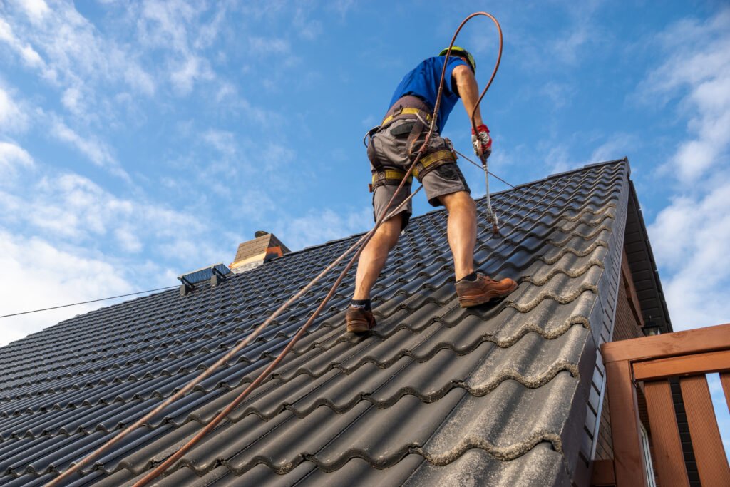 high-altitude worker painting a roof